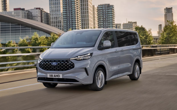 Bild på en silver färgad Ford E-Tourneo Custom i fart snett framifrån